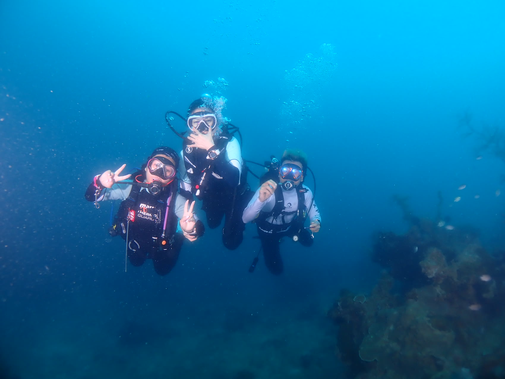 Happy divers giving the OK sign underwater